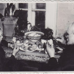 Fotonuotrauka. Grupinė. Senelis (dešinėje) su anūku (kairėje) dažo velykinius margučius prie uždaroje patalpoje esančio stalo. XX a. 3–4 deš. (Trakų muziejus, CC BY)